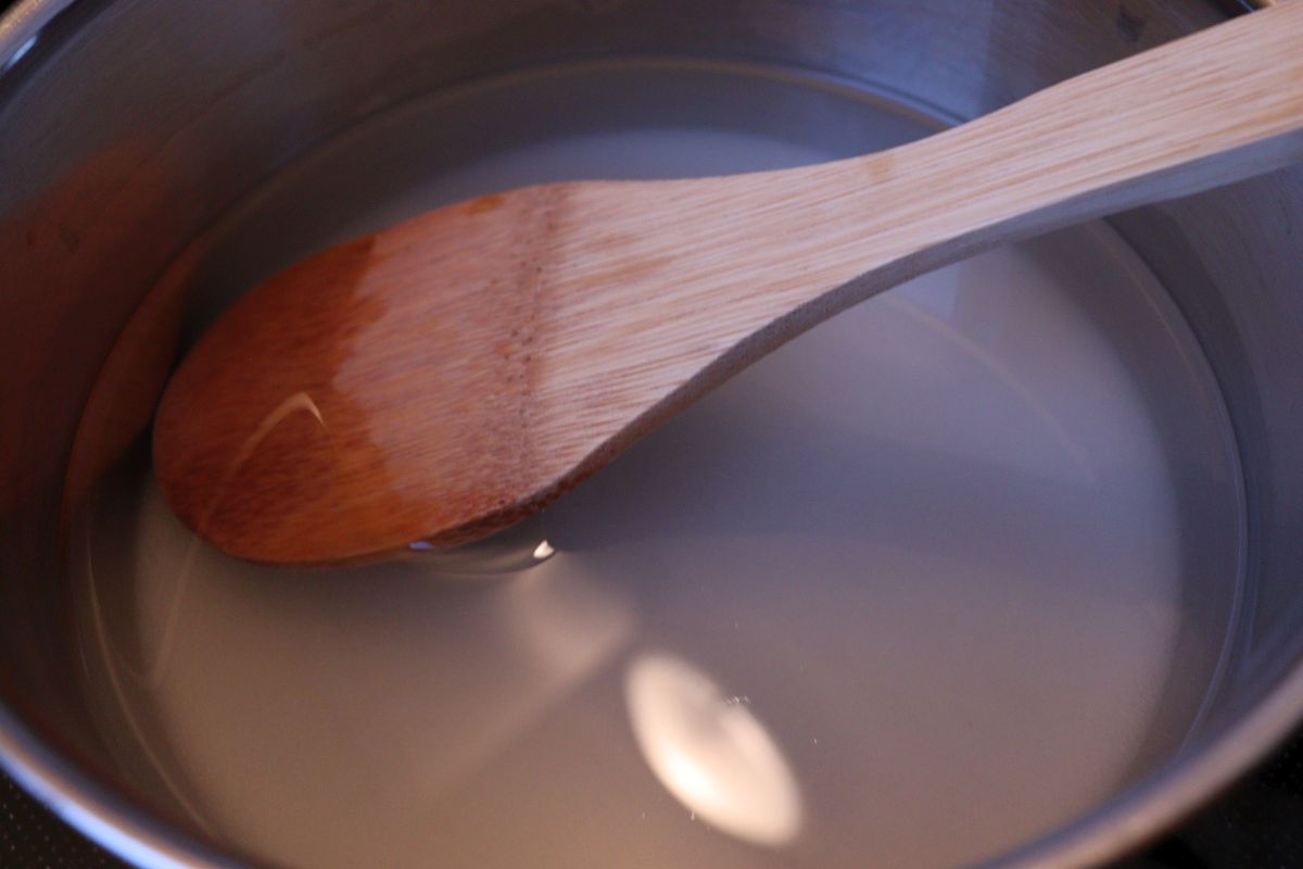 Boiling sugar with water in a pot, for making the syrup for elderflower confiture