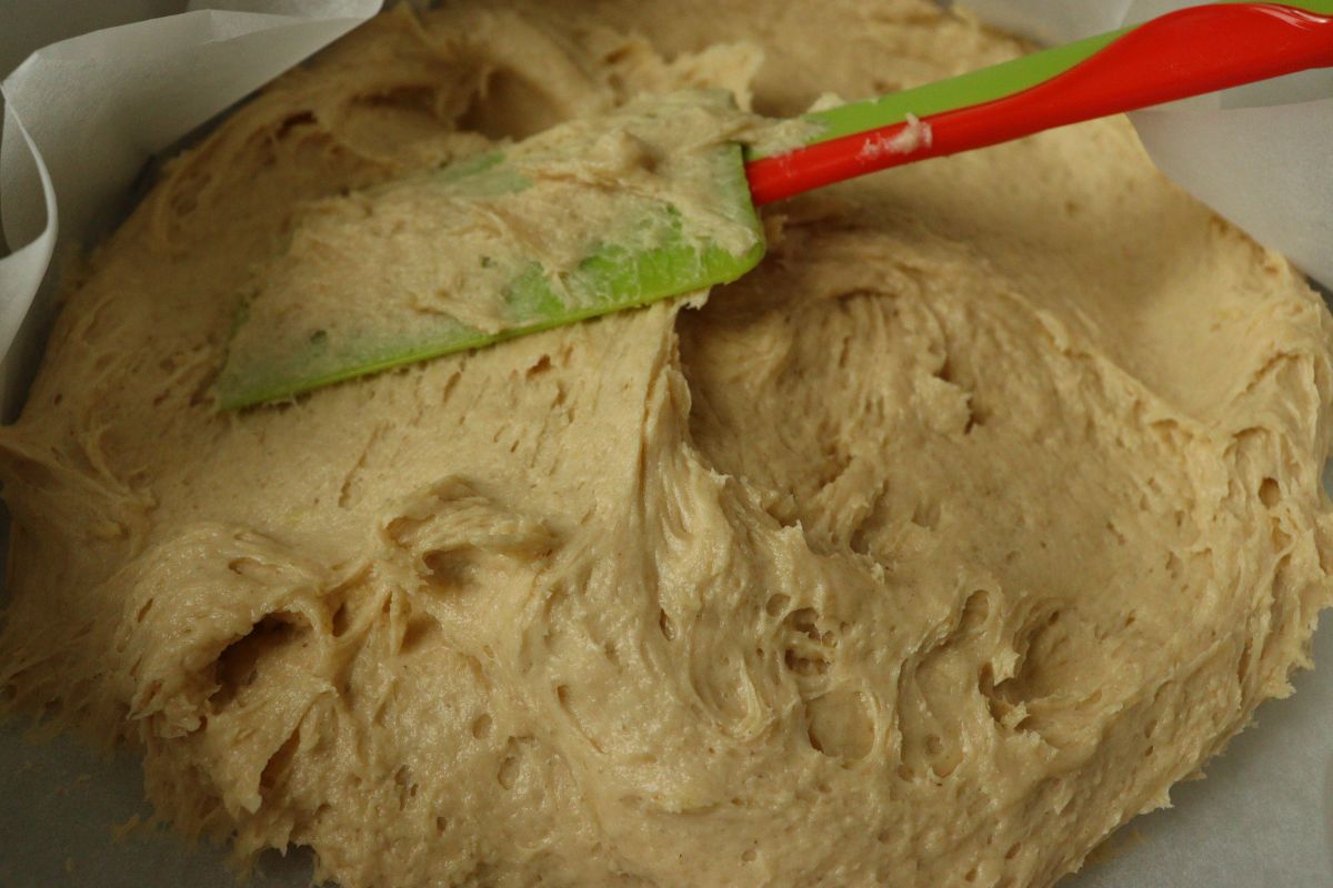 Thick batter in a pan for a rhubarb cake, leveled with a spatula