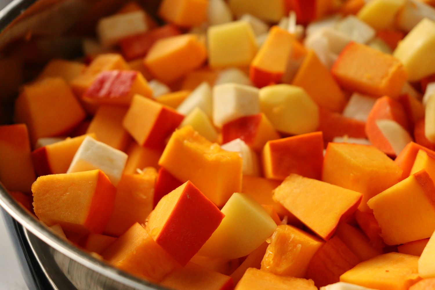 Cubed pumpkin, celery root, carrots, potatoes and onions for making pumpkin soup