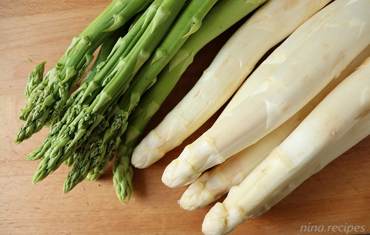 Varieties of Asparagus: white Asparagus and green Asparagus on a wooden copping board
