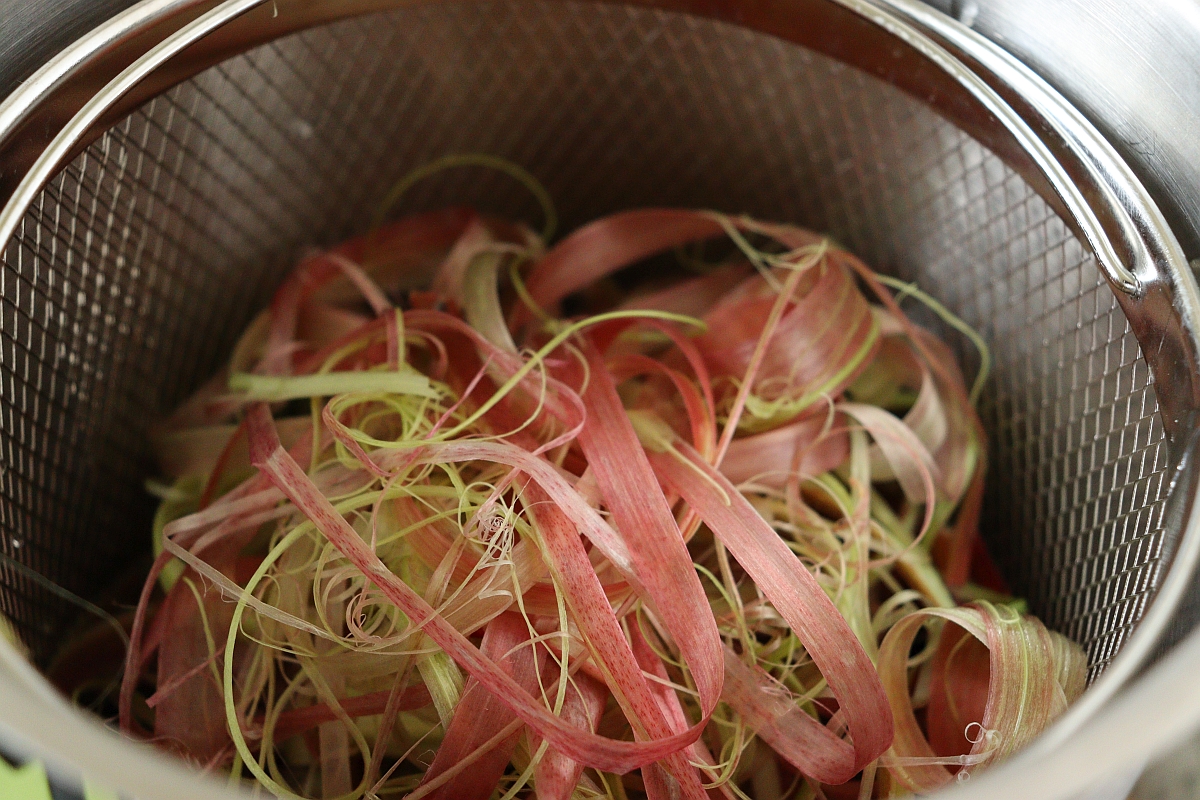 Peel of rhubarb in a pot which will be boiled for making lemonade