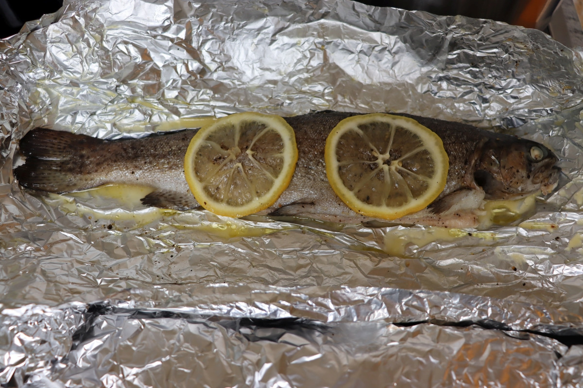 Baked trout in foil with lemon and sage leaves