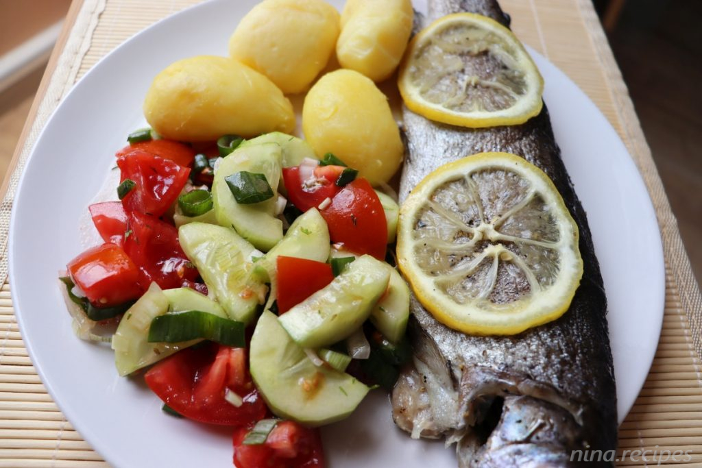 Baked trout in foil with lemon and sage leaves. served with boiled potatoes and salad