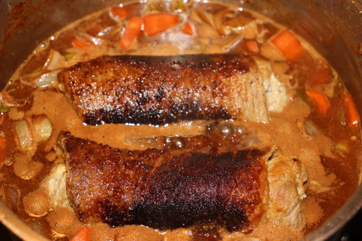 Simmering beef rolls and vegetable in a saucepan