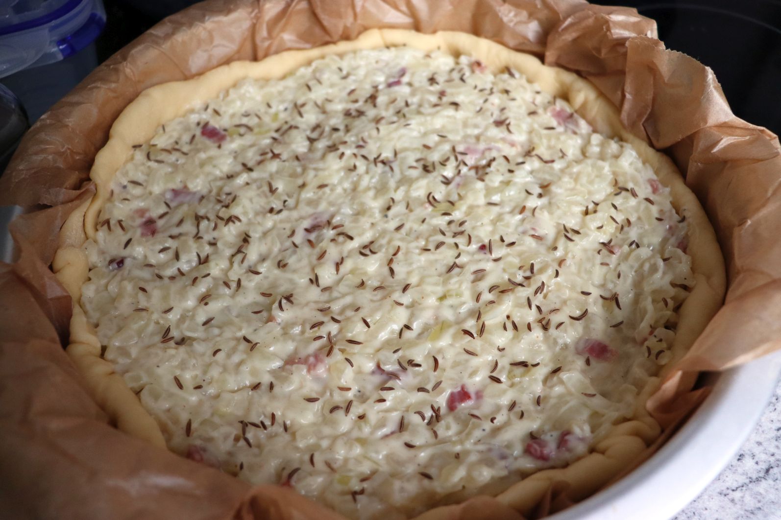 Raw Zwiebelkuchen - Onion Pie with onion and bacon filling and caraway seeds on top